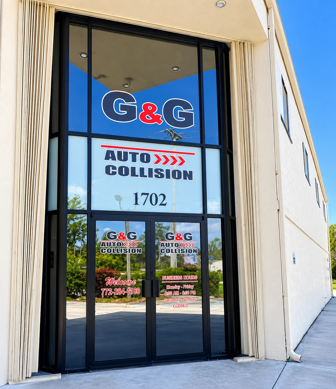 G&G Auto Collision's Port St. Lucie entrance, with the 1702 street number and shop signage on the glass doors.